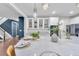 Bright kitchen with marble island, pendant lights, stainless appliances, and navy blue accent wall and stairwell at 3438 Cade Ct, Castle Rock, CO 80104