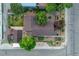 Aerial view of a home with a well-maintained roof, detached garage, mature trees, and neat landscaping at 205 Beech St, Hudson, CO 80642