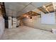 Unfinished basement with concrete floor, utility appliances, and open ceiling with exposed pipes and beams at 205 Beech St, Hudson, CO 80642