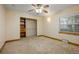 An empty bedroom with carpeted floors, closet with shelves and a window with natural light at 205 Beech St, Hudson, CO 80642