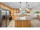 Well-lit kitchen with a large island, stainless steel appliances, and natural wood cabinets offer plenty of space at 205 Beech St, Hudson, CO 80642