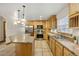 Bright kitchen features an island, stainless steel appliances, natural wood cabinetry, and tile flooring at 205 Beech St, Hudson, CO 80642