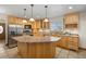 Bright kitchen features an island, stainless steel appliances, natural wood cabinetry, and tile flooring at 205 Beech St, Hudson, CO 80642