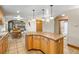 Spacious kitchen with island, natural wood cabinets, and tile flooring, open to the dining and living areas at 205 Beech St, Hudson, CO 80642
