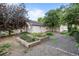 Charming house with a garden, lush greenery, and mature trees, creating a serene outdoor space at 205 Beech St, Hudson, CO 80642