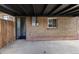 Back of house featuring a brick wall, a wooden fence, and a door leading inside the home at 6839 E 21St Ave, Denver, CO 80207