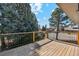 Exterior view from a wood back deck featuring pine trees and a clear blue sky at 10121 W 70Th Dr, Arvada, CO 80004