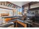 Basement bar area with dark counters, wood paneling, and a small black fridge at 10121 W 70Th Dr, Arvada, CO 80004