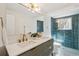 Stylish bathroom with double sink vanity, and a tiled shower behind glass at 10121 W 70Th Dr, Arvada, CO 80004