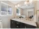 Bright bathroom with a double sink vanity, brass fixtures, and a large mirror for a modern look at 10121 W 70Th Dr, Arvada, CO 80004