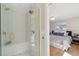 Luxurious shower with frameless glass, and a view of a bedroom with hardwood floors and a comfortable bed at 10121 W 70Th Dr, Arvada, CO 80004