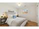 Cozy bedroom featuring hardwood floors, a comfortable bed, and a sunlit window at 10121 W 70Th Dr, Arvada, CO 80004
