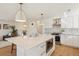 Modern kitchen with large island featuring white countertops, stainless steel appliances, and pendant lighting at 10121 W 70Th Dr, Arvada, CO 80004