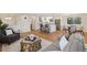 Open-concept living space with hardwood floors, flowing into a modern kitchen with stainless steel appliances at 10121 W 70Th Dr, Arvada, CO 80004