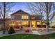 Evening view of the backyard patio with outdoor dining and seating areas under warm lighting at 15946 W Ellsworth Ln, Golden, CO 80401