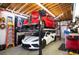 Spacious garage with car lift featuring two vehicles, one vintage and one modern at 15946 W Ellsworth Ln, Golden, CO 80401
