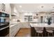 Bright kitchen with a marble backsplash, stainless steel appliances, a window over the sink, and an island with seating at 15946 W Ellsworth Ln, Golden, CO 80401