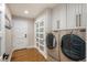 Well-organized laundry room with washer, dryer, storage cabinets and convenient access at 15946 W Ellsworth Ln, Golden, CO 80401