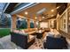 Spacious covered patio with brick columns, a ceiling fan, outdoor heaters, and comfortable sectional seating at 15946 W Ellsworth Ln, Golden, CO 80401