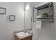 Compact bathroom featuring a wood vanity, framed wall art, and metal shelving at 837 E 98Th Ave # 405, Thornton, CO 80229