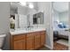 Bright bathroom featuring a wood vanity with white countertop and bedroom view at 837 E 98Th Ave # 405, Thornton, CO 80229