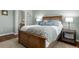 Beautiful bedroom with wood-look floors and ensuite access, featuring a bed, a dresser and two side tables with lamps at 837 E 98Th Ave # 405, Thornton, CO 80229