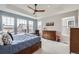 Spacious primary bedroom with tray ceiling, large windows, and a cozy seating area at 1832 Marlowe Cir, Erie, CO 80516