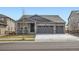Charming home with a three-car garage and covered porch, showcasing beautiful landscaping at 1832 Marlowe Cir, Erie, CO 80516