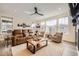 Bright living room with large windows, plush seating, and a ceiling fan at 1832 Marlowe Cir, Erie, CO 80516