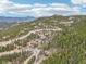 An aerial view of a wooded area with a house surrounded by trees with a long winding road at 800 Highway 72, Golden, CO 80403