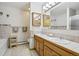Well-lit bathroom featuring a double sink vanity with tiled countertops, decorative mirrors, and a bathtub with a shower at 800 Highway 72, Golden, CO 80403