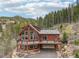 Stunning two-story home featuring a large deck and expansive windows to admire the surrounding mountain forest at 800 Highway 72, Golden, CO 80403