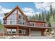Striking two-story house with large windows and inviting deck space, surrounded by a lush, green forest at 800 Highway 72, Golden, CO 80403