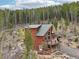 A wood-sided two-story house featuring a deck with chairs and an A-frame window design at 800 Highway 72, Golden, CO 80403