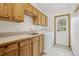 Bright laundry room with custom cabinets, tile floor and counter and a utility sink at 800 Highway 72, Golden, CO 80403