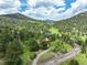 Elevated view of a scenic mountain home surrounded by lush greenery, nestled within a picturesque landscape at 31150 Manitoba Dr, Evergreen, CO 80439