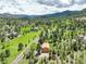 Gorgeous aerial view of mountain property surrounded by lush greenery and mature trees at 31150 Manitoba Dr, Evergreen, CO 80439
