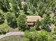An aerial view of a charming home nestled amidst lush greenery and trees, showcasing its tranquil and private setting at 31150 Manitoba Dr, Evergreen, CO 80439