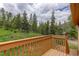 Deck overlooking a green forest filled with tall pine trees at 31150 Manitoba Dr, Evergreen, CO 80439