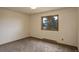 A carpeted room featuring a window bringing in natural light with neutral colored walls at 31150 Manitoba Dr, Evergreen, CO 80439