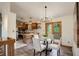 Dining room leading into the kitchen featuring a glass table and deck access at 31150 Manitoba Dr, Evergreen, CO 80439