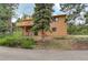 Exterior view of a home with a wooden deck and stairs, surrounded by trees at 31150 Manitoba Dr, Evergreen, CO 80439