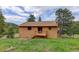 Back exterior view of home with wooden deck and outdoor access at 31150 Manitoba Dr, Evergreen, CO 80439