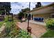 Backyard featuring a well-maintained patio area with outdoor seating, lush plants, and manicured lawn at 10373 W 75Th Ave, Arvada, CO 80005