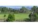A large green grassy backyard overlooking treelines and distant mountain peaks on a clear day at 10373 W 75Th Ave, Arvada, CO 80005