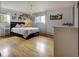Bright bedroom featuring hardwood floors, a cozy bed, and a unique chandelier lighting fixture at 10373 W 75Th Ave, Arvada, CO 80005