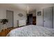 Bedroom with light gray doors, hardwood flooring, a modern light fixture and patterned bedspread at 10373 W 75Th Ave, Arvada, CO 80005