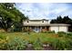 Charming two-story home with a well-manicured lawn, beautiful flowerbeds and a bright blue front door at 10373 W 75Th Ave, Arvada, CO 80005
