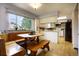 Bright eat-in kitchen area features wooden benches, a large window, and white cabinets at 10373 W 75Th Ave, Arvada, CO 80005
