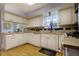 Well-lit kitchen with white cabinets, a practical layout, and neutral countertops at 10373 W 75Th Ave, Arvada, CO 80005